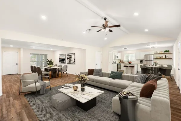 a living room with furniture and view of kitchen