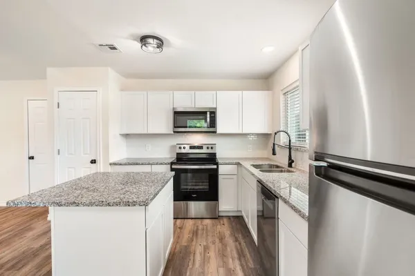 a kitchen with stainless steel appliances granite countertop a sink stove and refrigerator