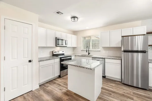 a kitchen with a refrigerator stove and sink