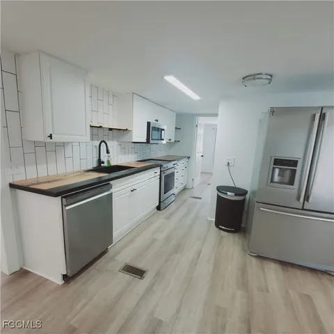 a kitchen with stainless steel appliances granite countertop a sink dishwasher stove and refrigerator