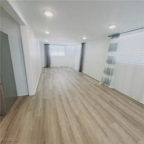 a view of empty room with wooden floor