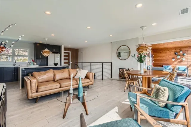 a living room with furniture kitchen view and a chandelier