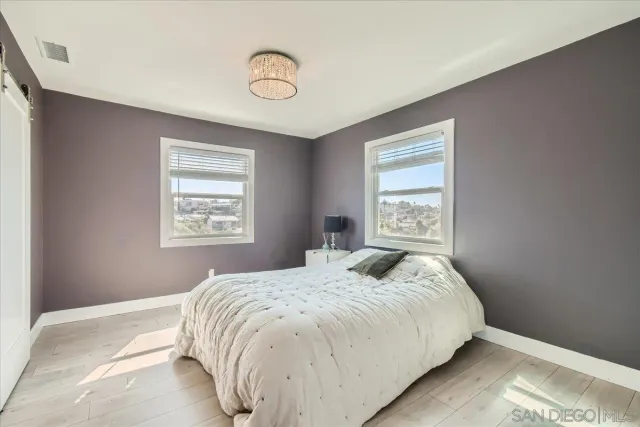 a bedroom with a large bed and a chandelier