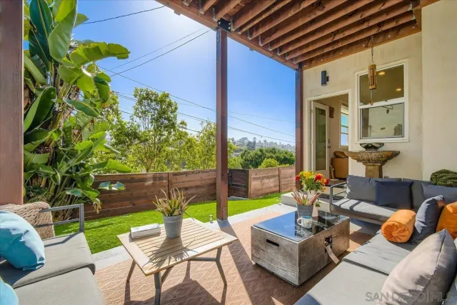 a view of backyard with table and chairs and potted plants