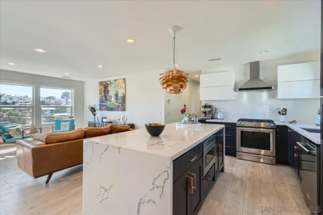 a kitchen with stainless steel appliances granite countertop a sink a stove and a refrigerator