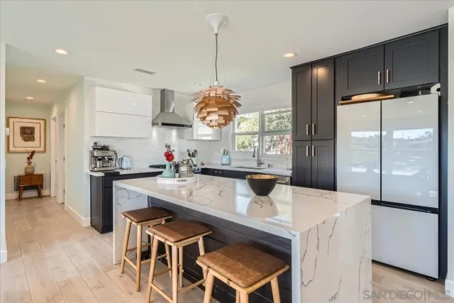 a kitchen with a dining table chairs sink and cabinets