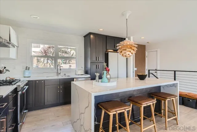 a kitchen with a dining table chairs sink and stove