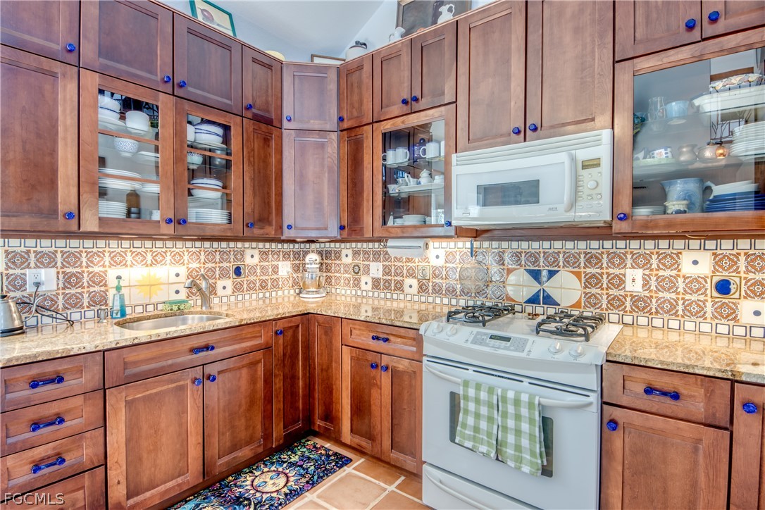2702 Bruce Street Matlacha, FL 33993 - Photo 20 of 50 a kitchen with stainless steel appliances granite countertop a sink stove and cabinets