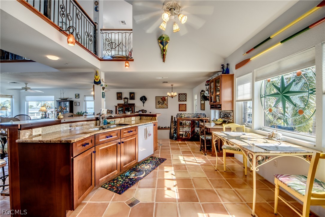2702 Bruce Street Matlacha, FL 33993 - Photo 21 of 50 a kitchen with stainless steel appliances granite countertop a stove a sink dishwasher and a dining table with wooden floor