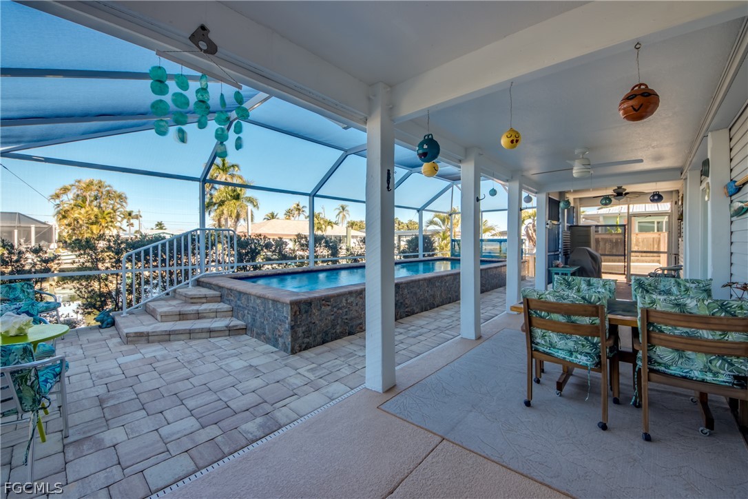 2702 Bruce Street Matlacha, FL 33993 - Photo 44 of 50 a view of a porch with dining table and chairs with a garden