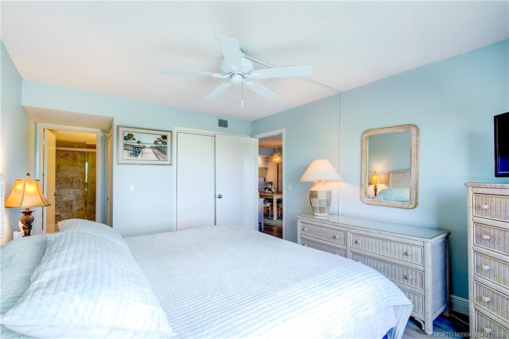 40 Northeast Plantation Road, Unit 209 Stuart, FL 34996 - Photo 21 of 36 a bedroom with a bed and a chandelier