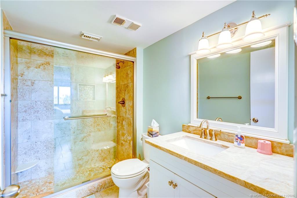 40 Northeast Plantation Road, Unit 209 Stuart, FL 34996 - Photo 22 of 36 a bathroom with a granite countertop sink toilet and shower