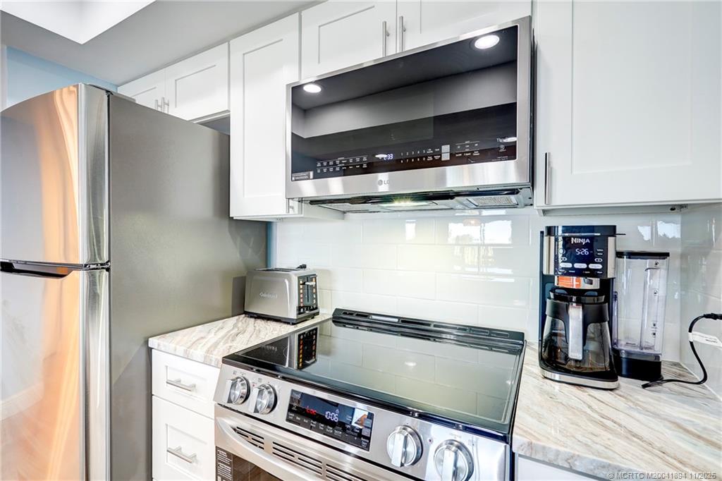 40 Northeast Plantation Road, Unit 209 Stuart, FL 34996 - Photo 6 of 36 a kitchen with a stove and a refrigerator