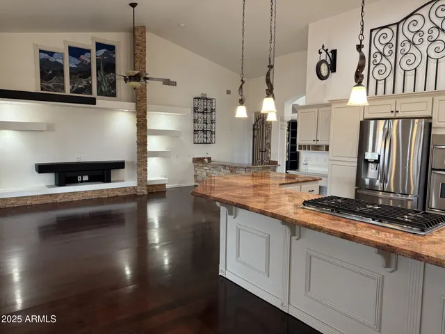 a kitchen with stainless steel appliances granite countertop a stove a sink and a refrigerator