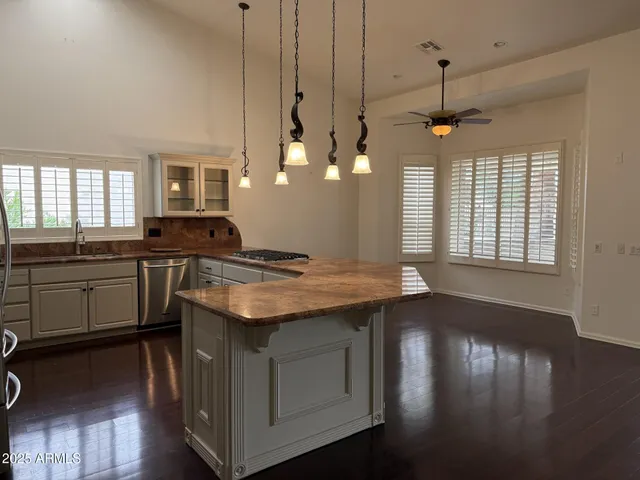 a kitchen with stainless steel appliances granite countertop a stove a sink dishwasher a refrigerator and wooden floor