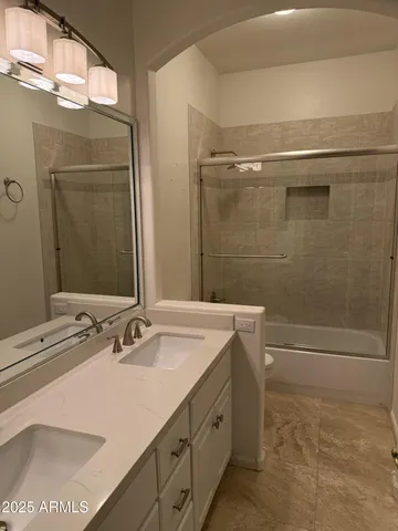 a bathroom with a sink shower and a mirror
