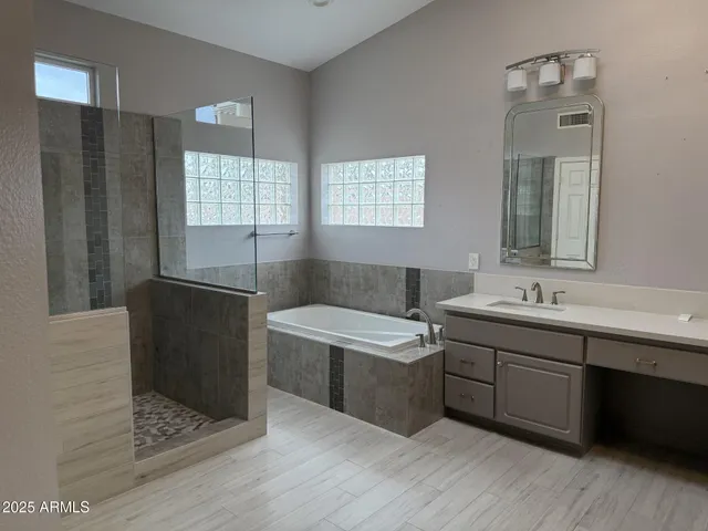 a bathroom with a tub sink and mirror
