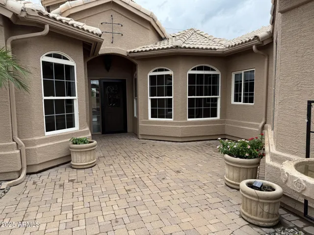 a front view of a house with a potted plant and a window
