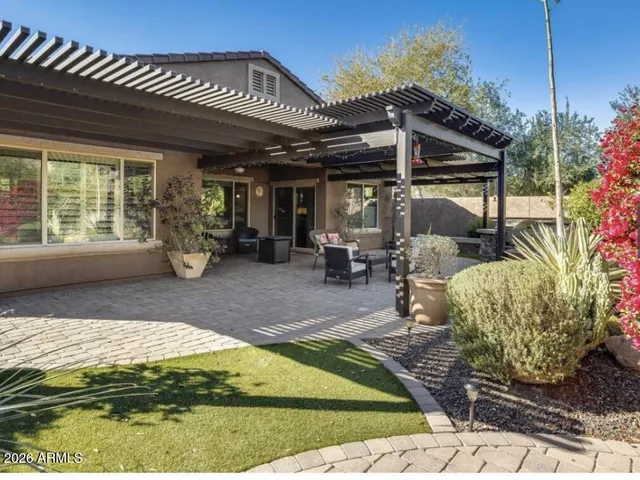 a view of a patio with table and chairs potted plants and large tree