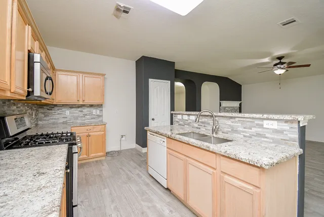 a kitchen with stainless steel appliances granite countertop a sink and cabinets