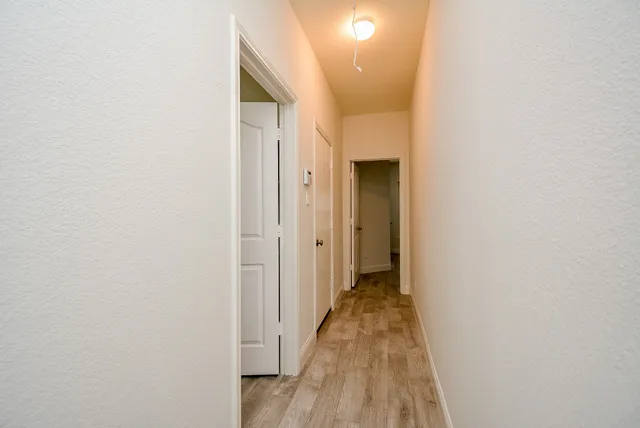 a view of a hallway with wooden floor