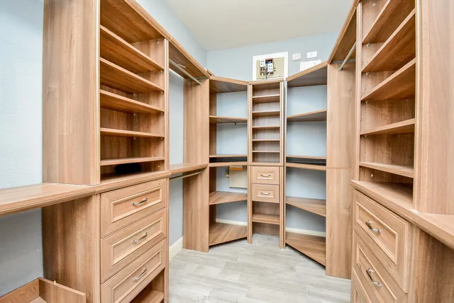 a view of walk in closet with empty racks