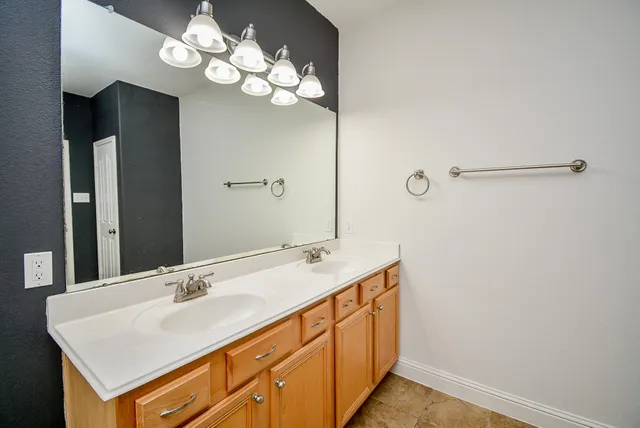 a bathroom with a sink a light fixture and a mirror