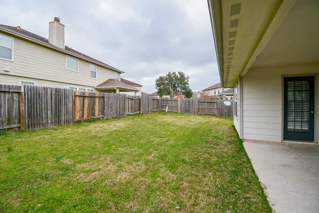 a backyard of a house with table and chairs