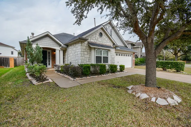 a view of a house with backyard and trees