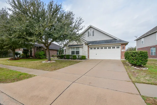 a view of house with yard and tall tree