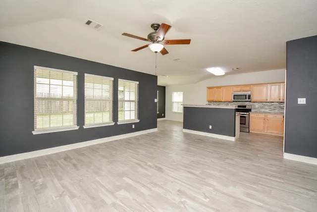 a view of an empty room with window and cabinet