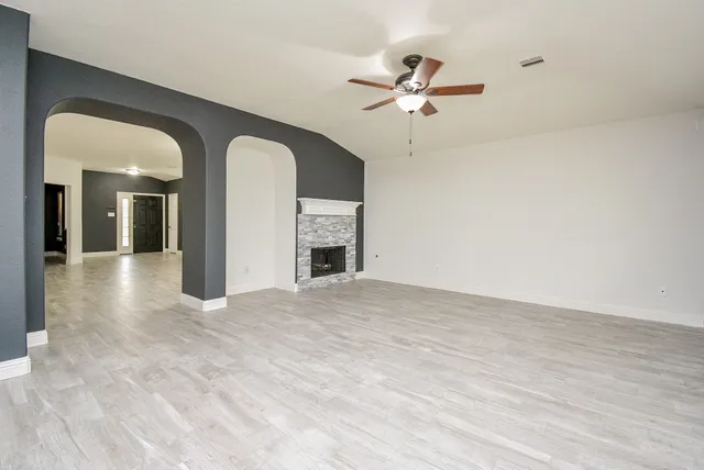 a view of empty room with wooden floor