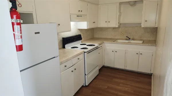 a kitchen with white cabinets and white appliances
