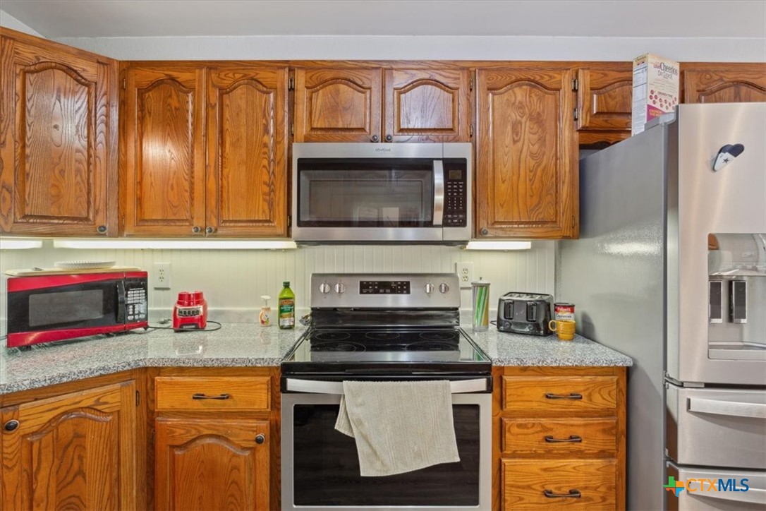 8 West Aztec Lane Belton, TX 76513 - Photo 16 of 37 a kitchen with stainless steel appliances granite countertop a refrigerator and a stove top oven