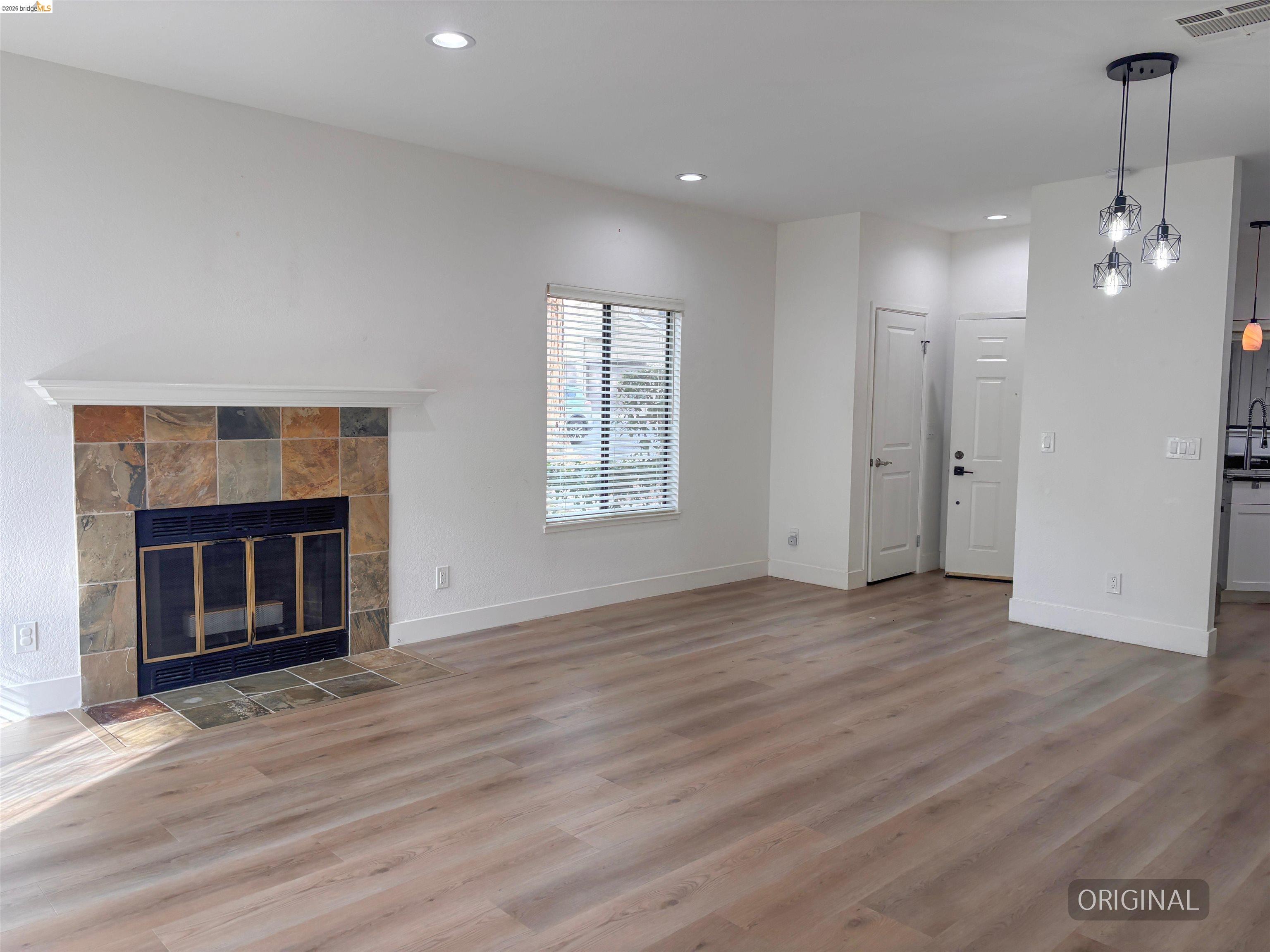 450 Pine Ridge Drive San Ramon, CA 94582 - Photo 8 of 18 an empty room with wooden floor fireplace and windows