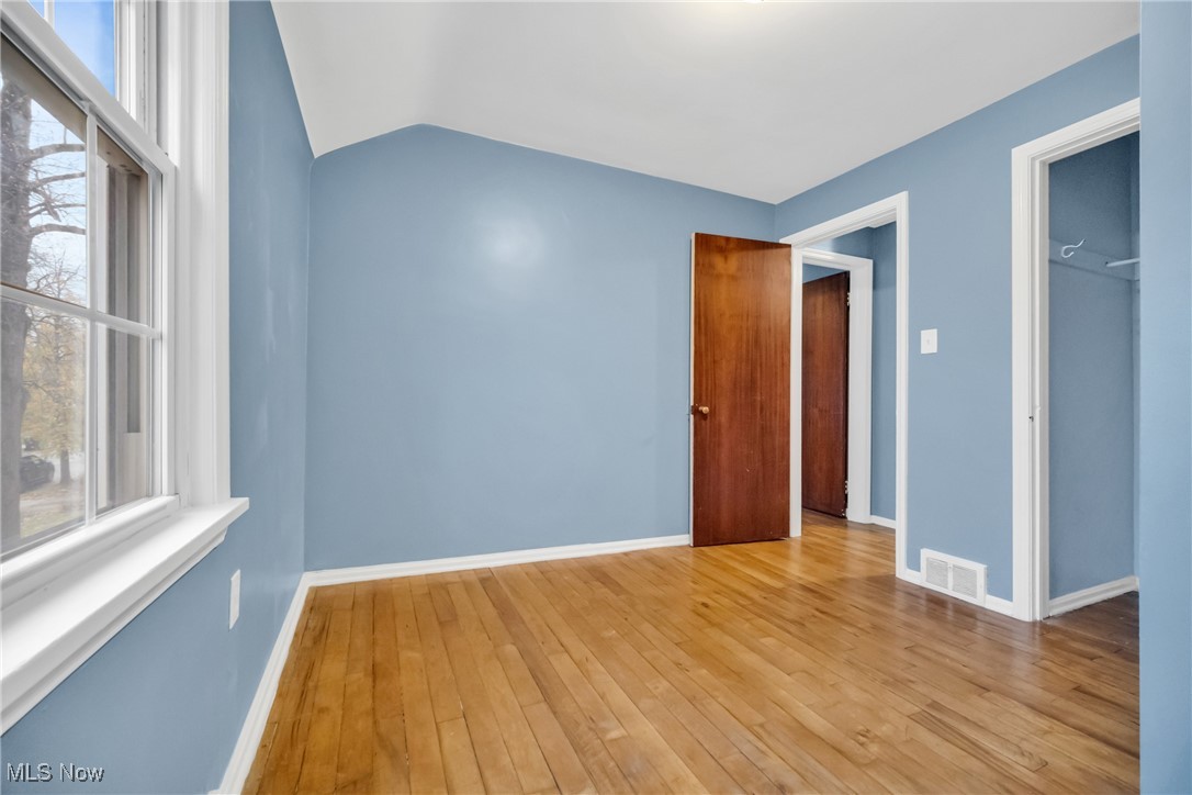 1605 Laclede Road Cleveland, OH 44121 - Photo 33 of 40 Unfurnished room featuring vaulted ceiling, baseboards, light wood-style floors, and visible vents