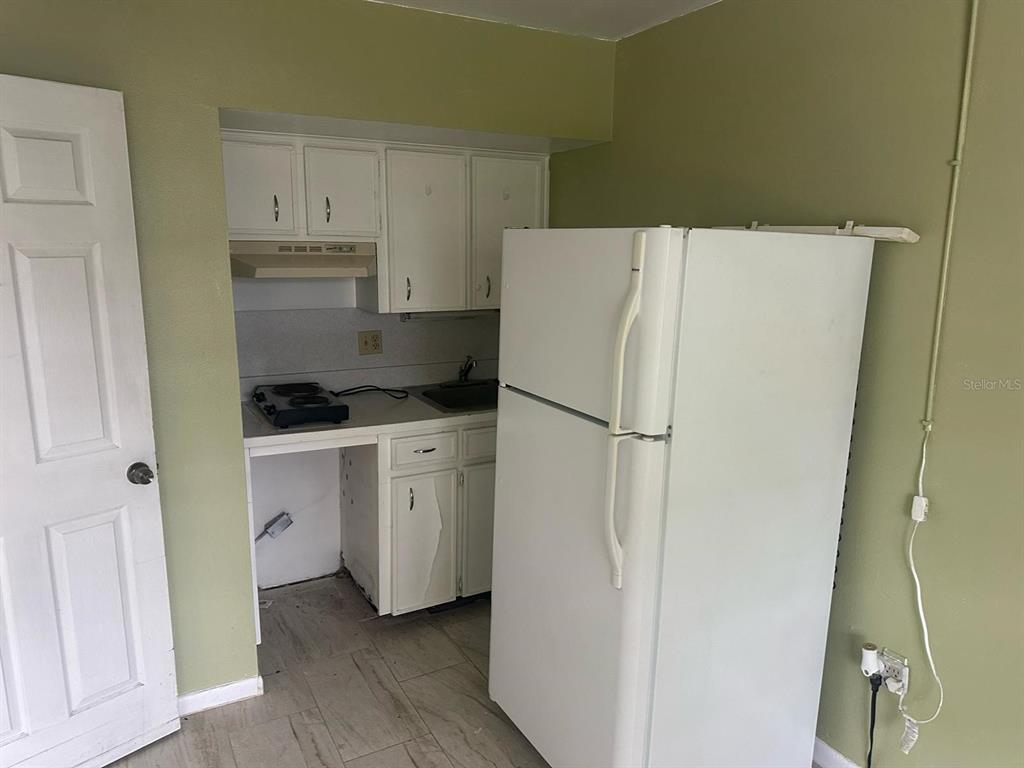 214 North Chestnut Road Lakeland, FL 33815 - Photo 5 of 6 a kitchen with white cabinets and white appliances