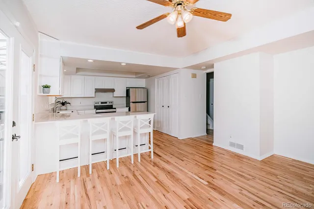 a view of kitchen with stainless steel appliances wooden floor