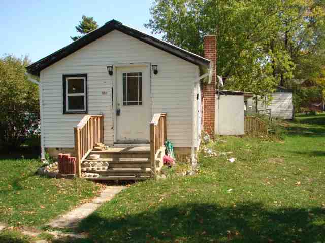 a view of backyard of house with wooden fence and trees