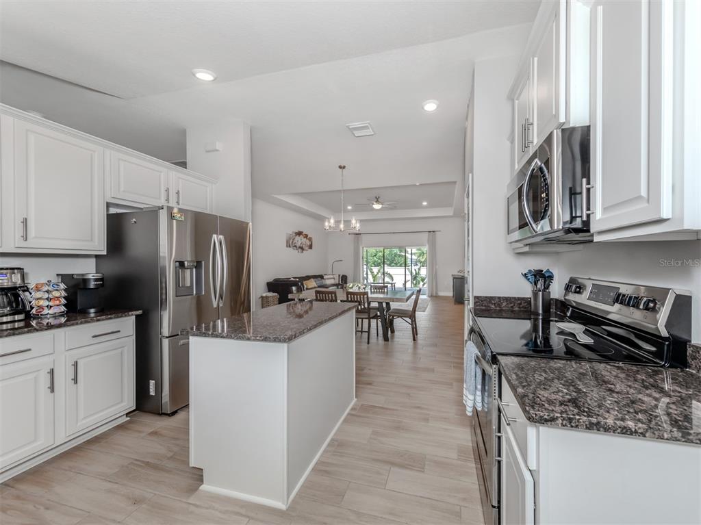 1190 Euclid Road Venice, FL 34293 - Photo 27 of 100 a kitchen with stainless steel appliances granite countertop a sink stove and refrigerator