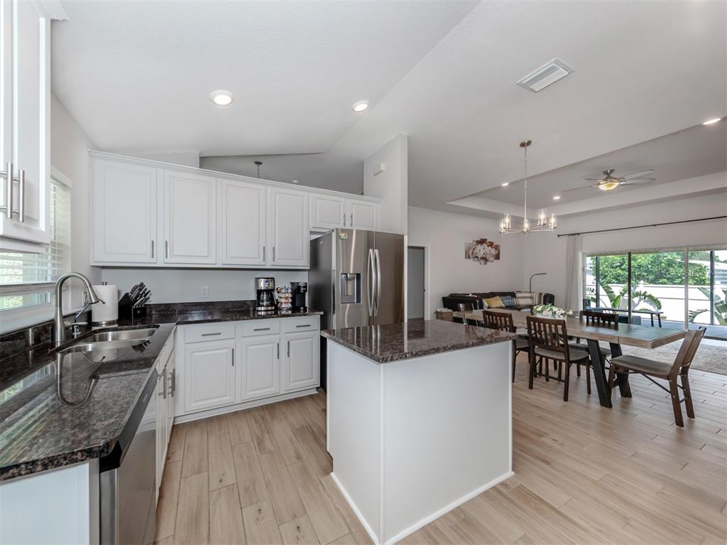 1190 Euclid Road Venice, FL 34293 - Photo 28 of 100 a kitchen with stainless steel appliances granite countertop sink stove top oven and cabinets