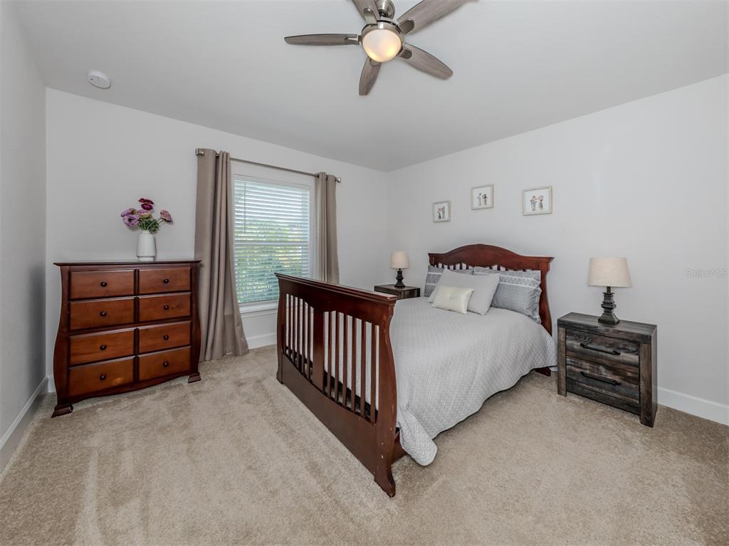 1190 Euclid Road Venice, FL 34293 - Photo 34 of 100 a bedroom with a bed and a chandelier