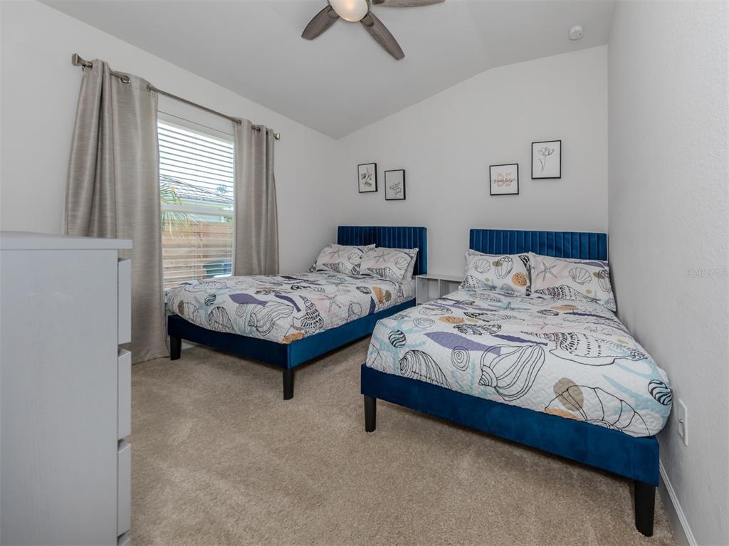 1190 Euclid Road Venice, FL 34293 - Photo 36 of 100 a bedroom with two beds and a chandelier