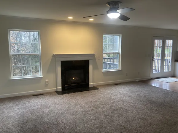 a view of an empty room with window and fireplace
