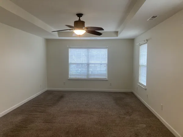 en empty room with windows and ceiling fan