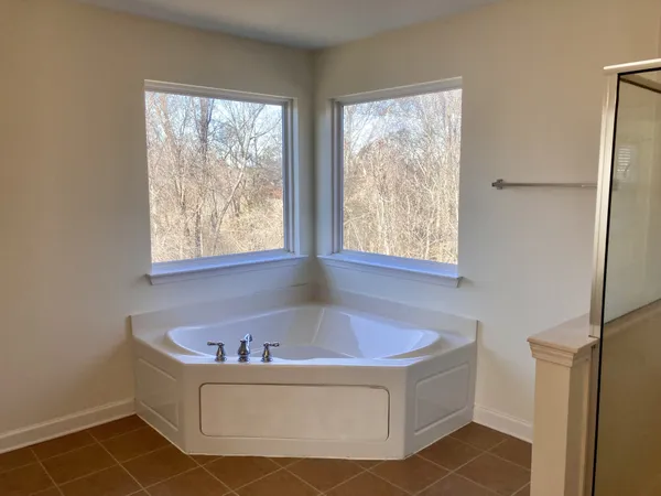 a bathroom with bathtub and window