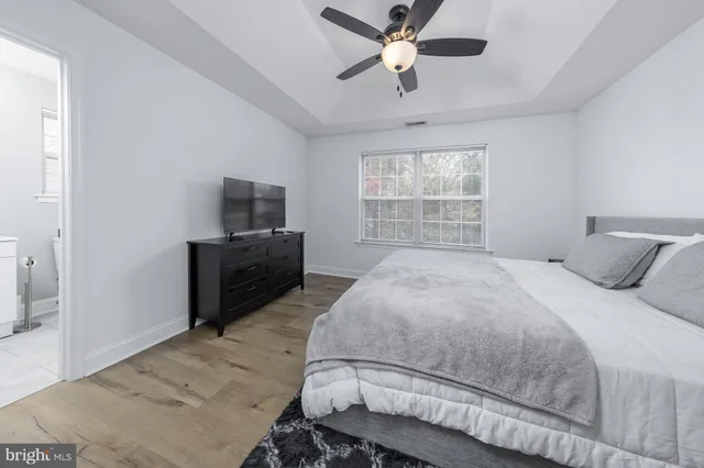 a bedroom with a bed and a television on dresser