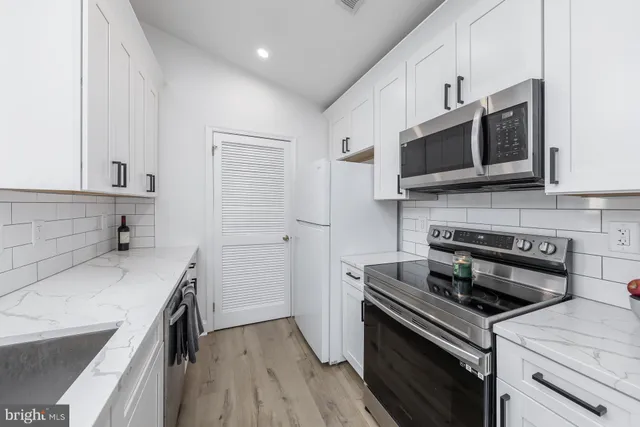 a kitchen with stainless steel appliances a stove microwave and sink
