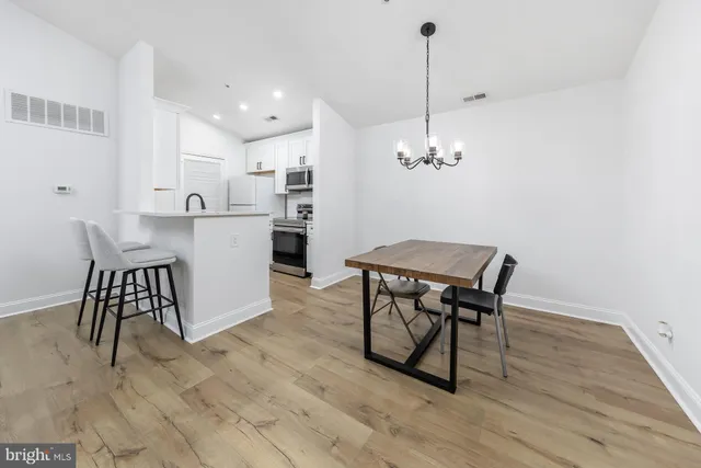 a living room with furniture a dining table and a chandelier