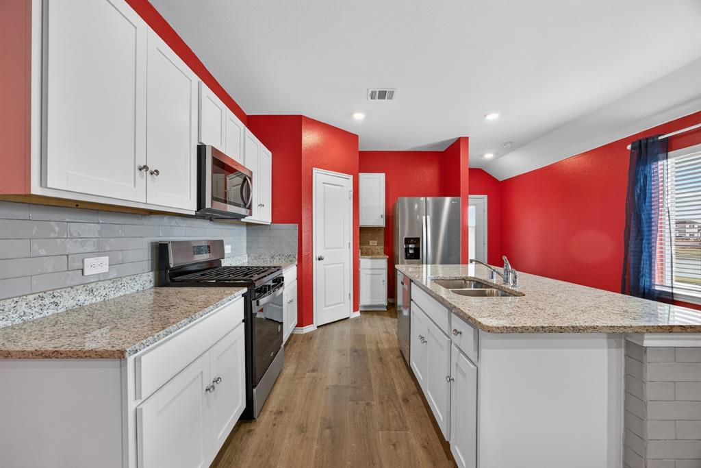709 Chipper Trail Lavon, TX 75166 - Photo 5 of 17 a kitchen with stainless steel appliances granite countertop a stove a sink and a refrigerator